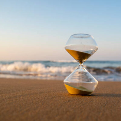 Flowing hourglass on the beach at sunrise